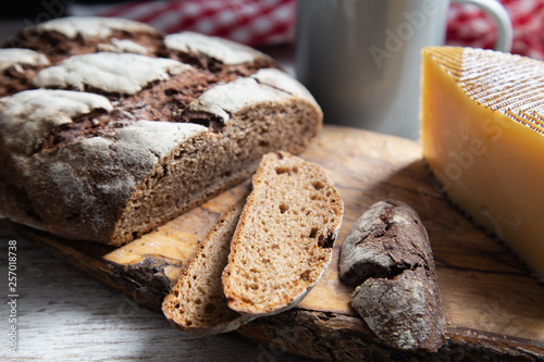 sliced rye bread on a rustic table with a plaid cloth a cheese and a mug