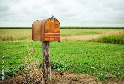 An old rusty mailbox in a field.