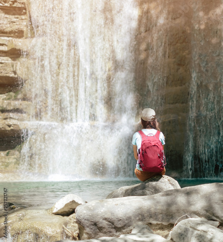 Female explorer enjoying view of waterfall.