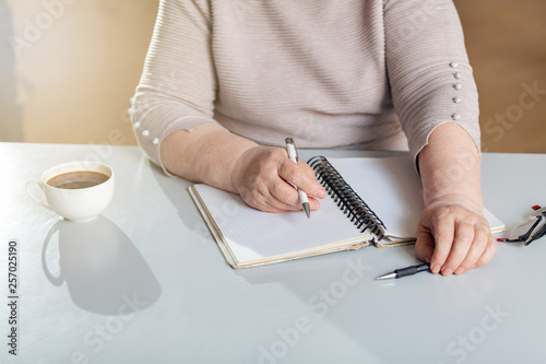 A woman takes notes in a notebook in the office.