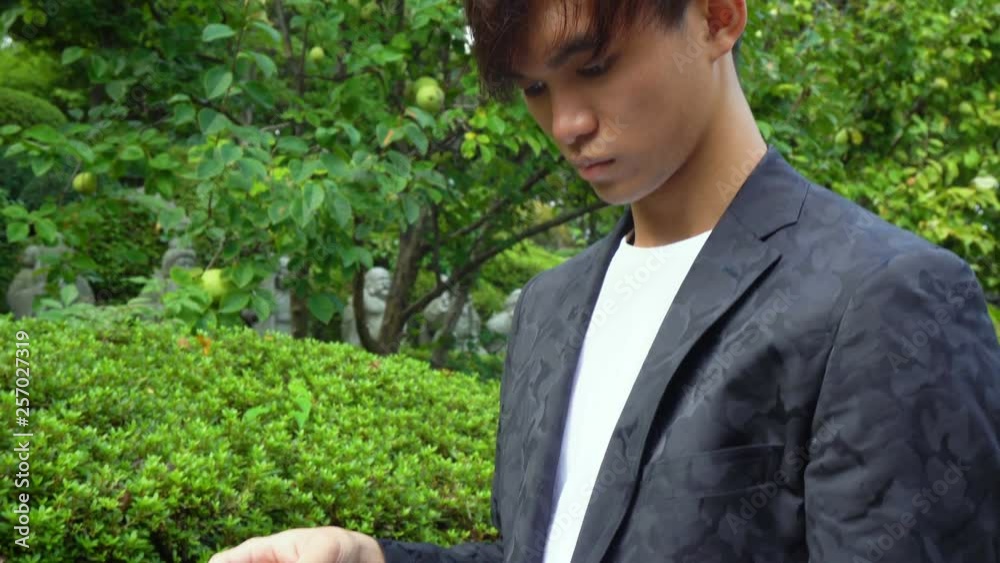 Young Asian Man Using Large Tablet Outdoors Young Asian Man Using Large Tablet Outdoors