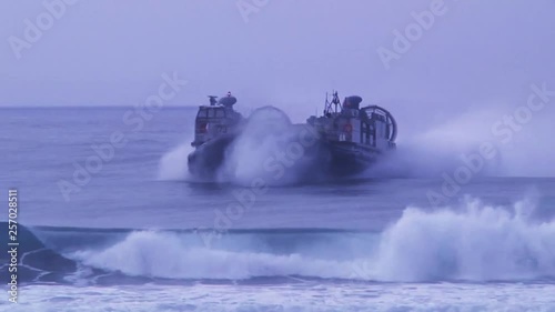 Military hovercraft arriving to the coast.