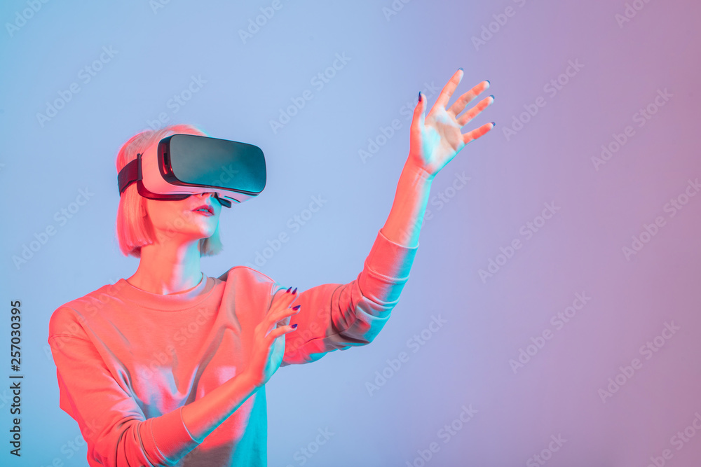 attractive girl touching air during the VR experience isolated on blue background, close up photo. copy space attractive girl touching air during the VR experience isolated on blue background, close up photo. copy space