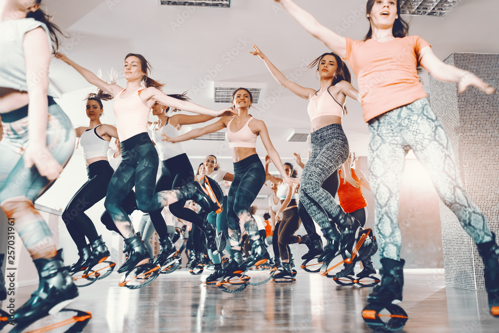 Group of cheerful sporty women wearing kangoo jumps boots and jumping in gym. You have to believe in yourself.