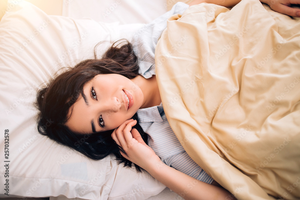 Portrait pretty young girl on bed in modern apartment in the morning Portrait pretty young girl on bed in modern apartment in the morning