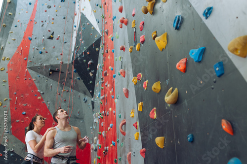 thoughtful man and woman analyzing the route of climbing at sport center. low angle view. copy space.