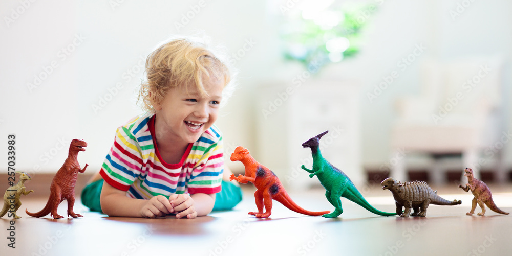 Child playing with toy dinosaurs. Kids toys. Child playing with toy dinosaurs. Kids toys.
