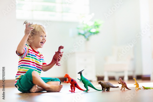 Child playing with toy dinosaurs. Kids toys. photo