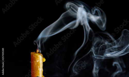 The smoke from an extinguished candle on a black background.