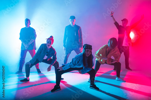 Canvas-taulu Group of male and female dancers in colorful neon light having fun dancing