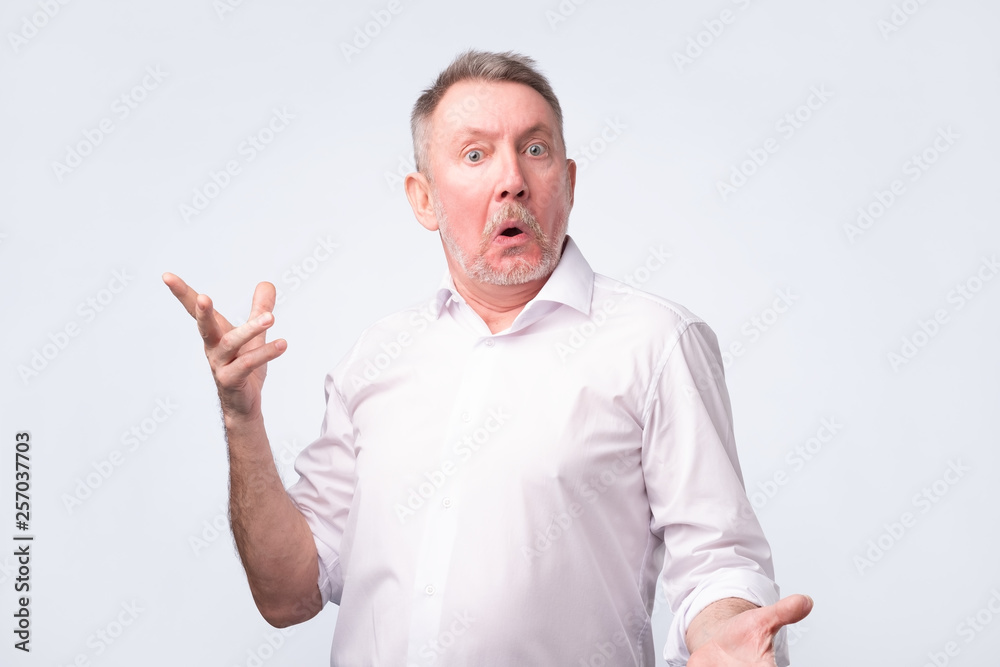 Fototapeta premium Astonished man trying to argue with his wife.