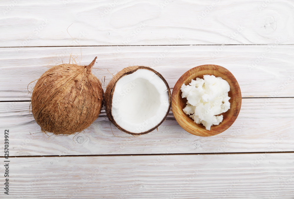 Flat lay background of coconut, coconut shell, hard oil in wooden bowl on white wooden table
