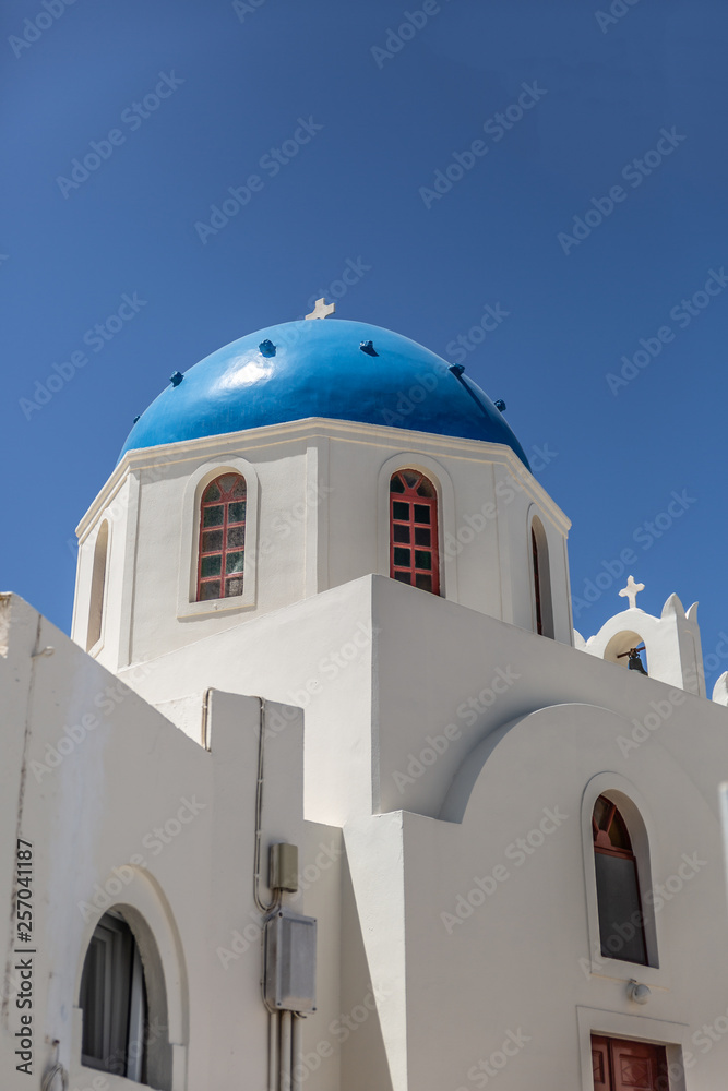 Traditional white church with a Blue dome, perched on the side of the cliff, Oia, Santorini, Greece