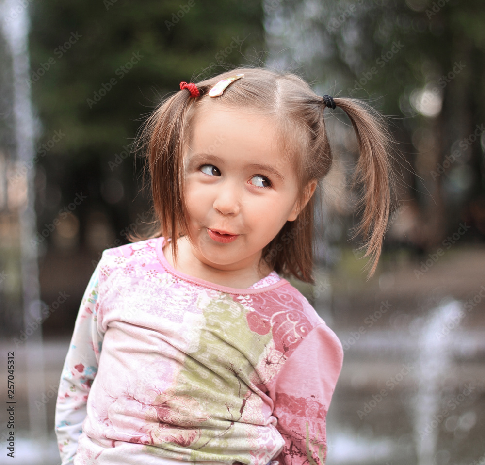 pretty little girl on the background of the city fountain