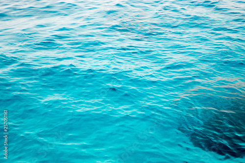 Blue clear water. Beautiful blue sea wave photograph close up. Beach vacation at sea or ocean. Background to insert images and text. Tourism, travel.