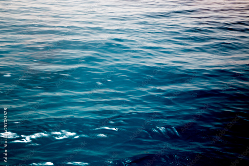 Fototapeta premium Blue clear water. Beautiful blue sea wave photograph close up. Beach vacation at sea or ocean. Background to insert images and text. Tourism, travel.