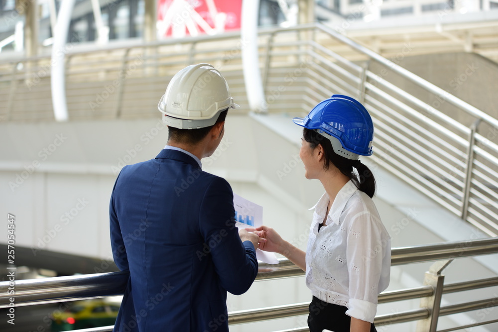 Young engineers and secretaries come to check the work at the construction site. At the business district of the city Young engineers and secretaries come to check the work at the construction site. At the business district of the city