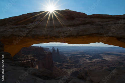 Mesa Arch with rising sun framing view of the canyon landscape of Canyonlands National Park, Utah, USA
