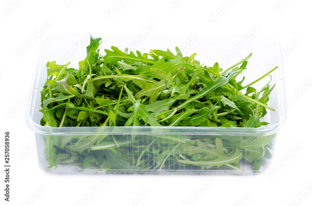 Arugula in plastic container on white background isolation Arugula in plastic container on white background isolation