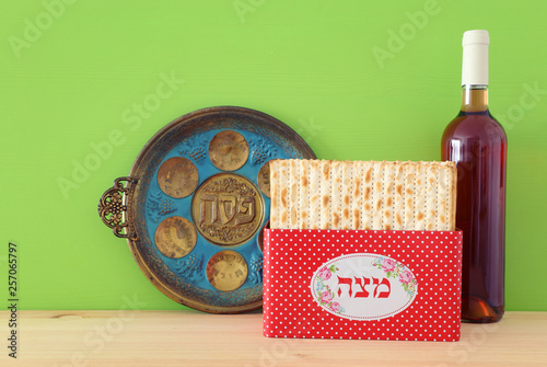 Pesah celebration concept (jewish Passover holiday). Translation for Hebrew Text over plate: (PESAH) PASSOVER, and Matzah utensils text: Matza