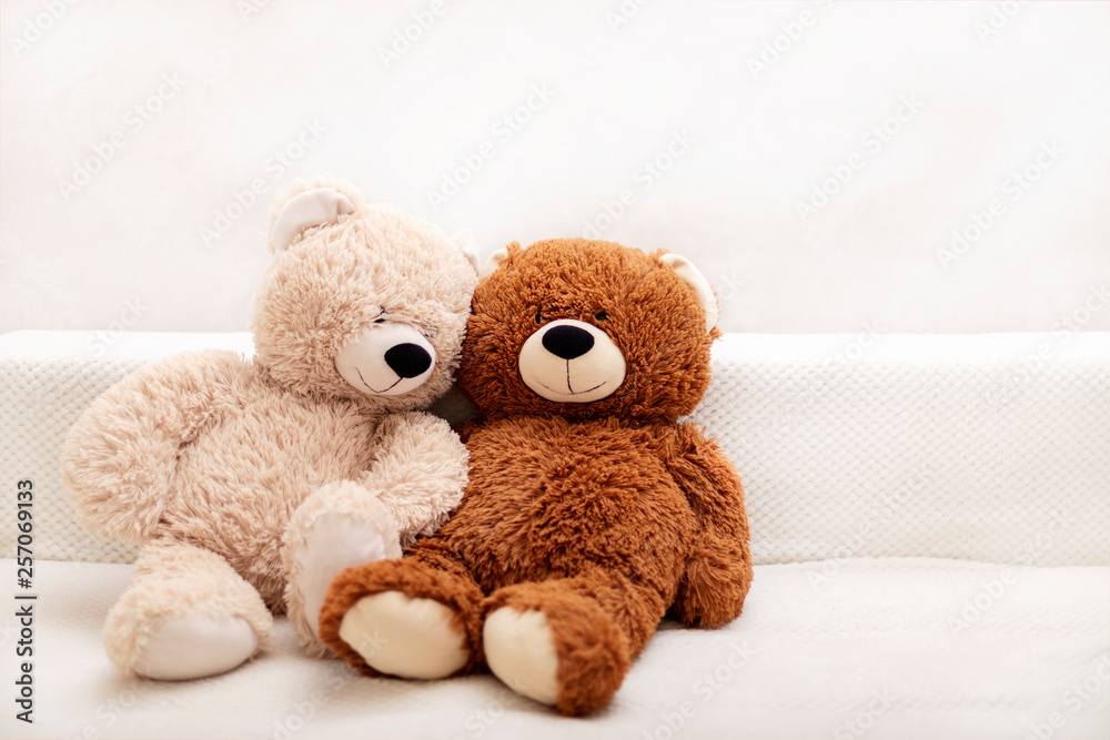 Children's toys - bears of brown and beige color are sitting on the sofa.