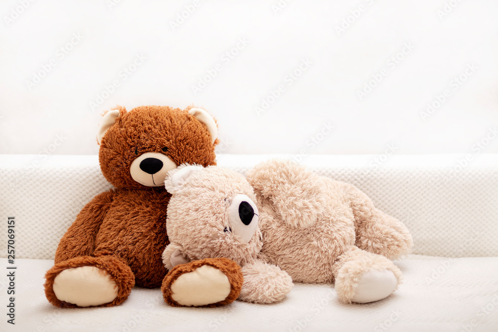 Children's toys - bears of brown and beige color are sitting on the sofa.