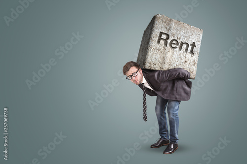 Conceptual image of a man burdened by high rent photo