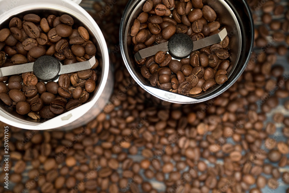 Fototapeta premium Two coffee grinders with coffee beans isolated on the wooden tables