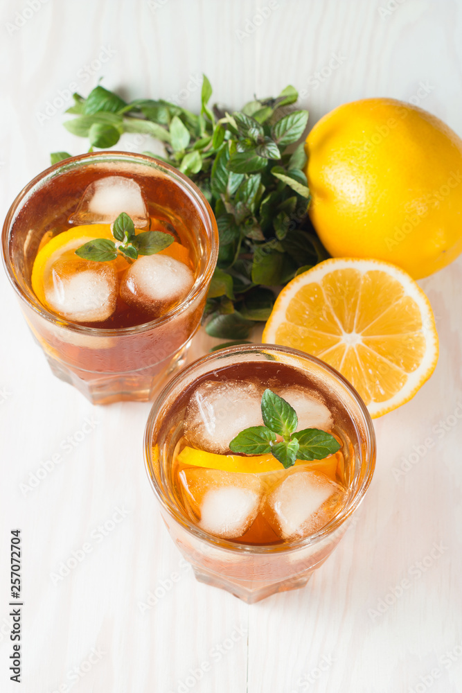 Refreshing citrus lemonade, summer drink. Ice tea with fresh lemon and mint on wooden background. Refreshment beverage concept. Refreshing citrus lemonade, summer drink. Ice tea with fresh lemon and mint on wooden background. Refreshment beverage concept.