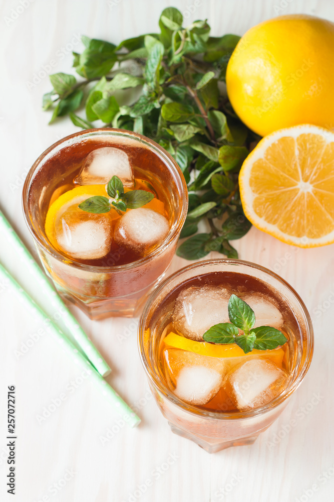 Refreshing citrus lemonade, summer drink. Ice tea with fresh lemon and mint on wooden background. Refreshment beverage concept. Refreshing citrus lemonade, summer drink. Ice tea with fresh lemon and mint on wooden background. Refreshment beverage concept.
