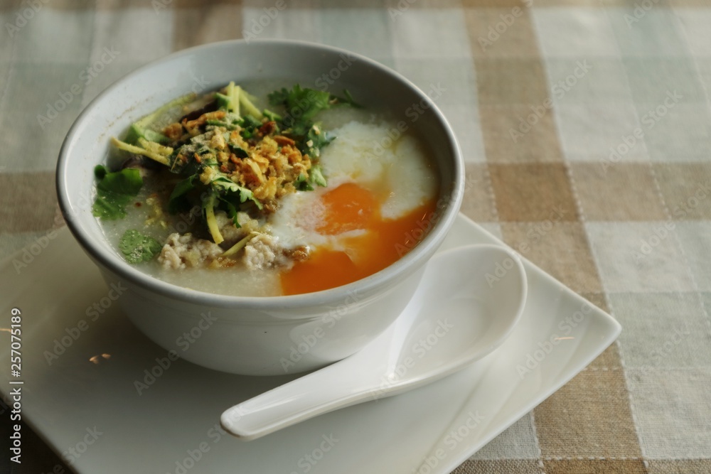 Rice porridge with egg on a table. Rice porridge with egg on a table.
