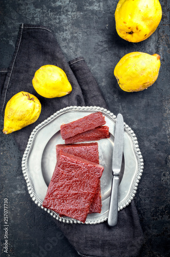 Traditional Spanish dulce de membrillo as fruit bread with quince as top view on a pewter plate photo