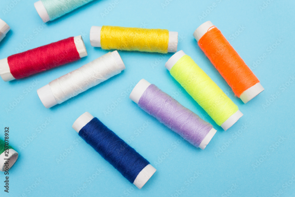 Colored sewing thread on a blue background Colored sewing thread on a blue background