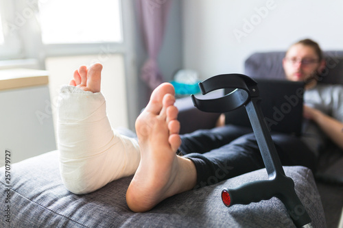 Boy with crutches and broken leg at home