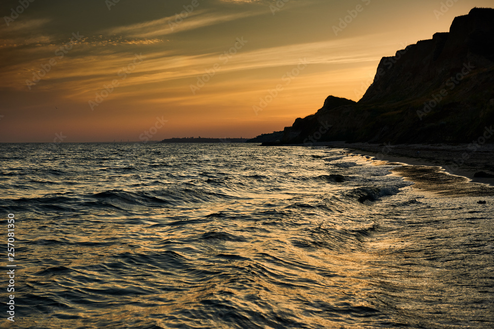 beautiful sunset, sea landscape, sea coast with high hills, wild nature