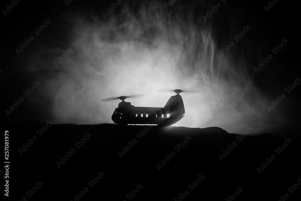 Silhouette of military helicopter ready to fly from conflict zone. Decorated night footage with helicopter starting in desert with foggy toned backlit. Selective focus. Silhouette of military helicopter ready to fly from conflict zone. Decorated night footage with helicopter starting in desert with foggy toned backlit. Selective focus.