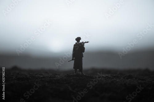 Military soldier silhouette with bazooka. War Concept. Military silhouettes fighting scene on war fog sky background, Soldier Silhouette aiming to the target at night photo