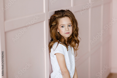 cute little girl posing on a pink background