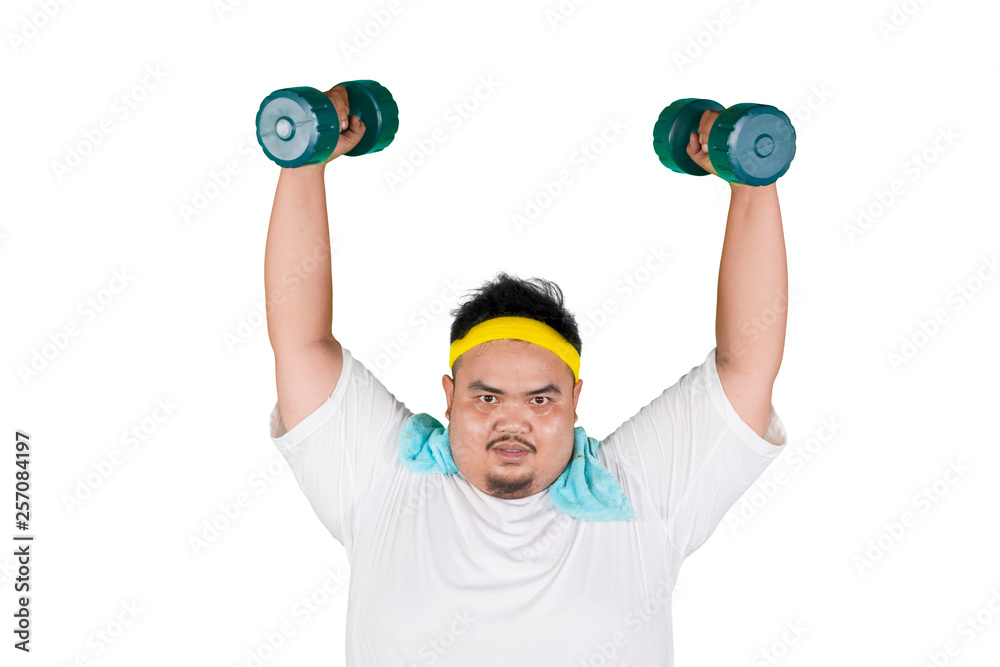 Asian fat man lifting two dumbbells on studio