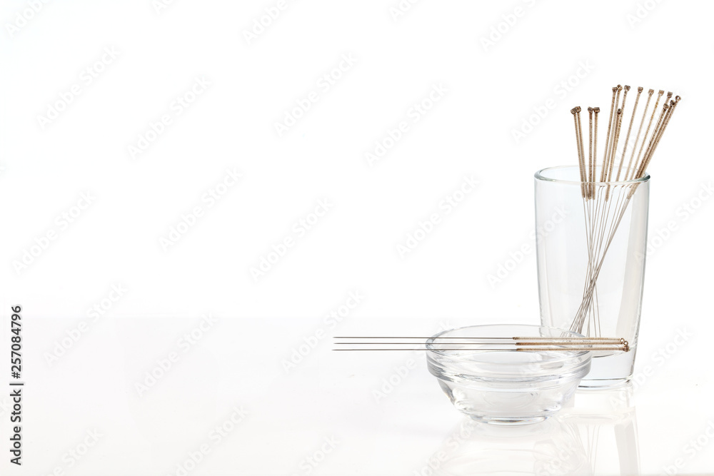 Silver needles for traditional Chinese acupuncture medicine. White background. - obrazy, fototapety, plakaty 