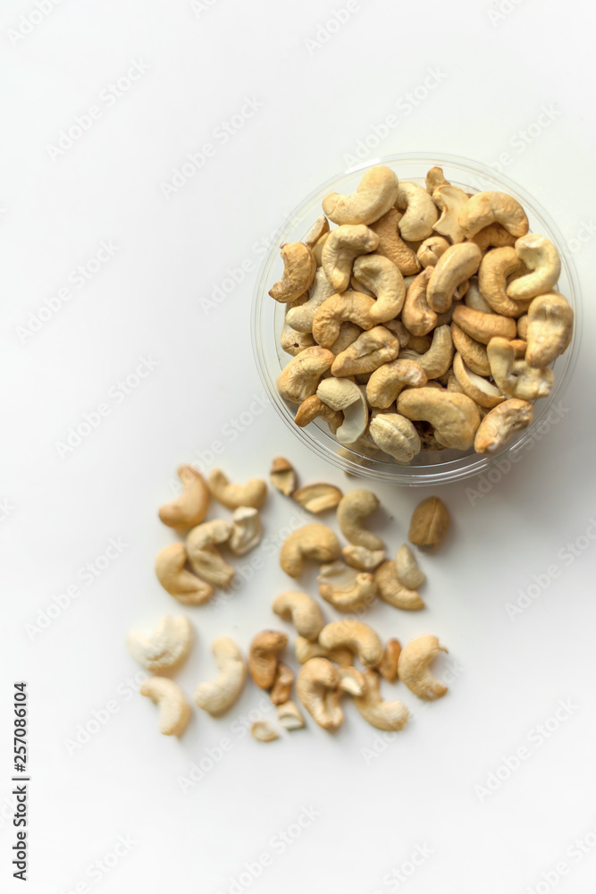 Healthy food for background image close up cashew nuts. Nuts texture on white grey table top view on the cup plate Healthy food for background image close up cashew nuts. Nuts texture on white grey table top view on the cup plate