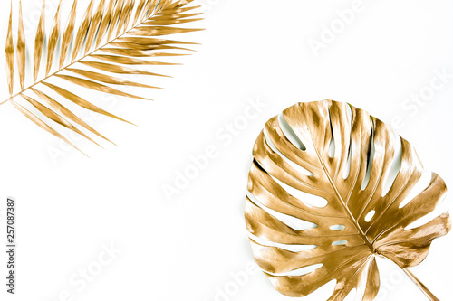 Gold tropical palm leaves Monstera on white background. Flat lay, top view minimal concept.