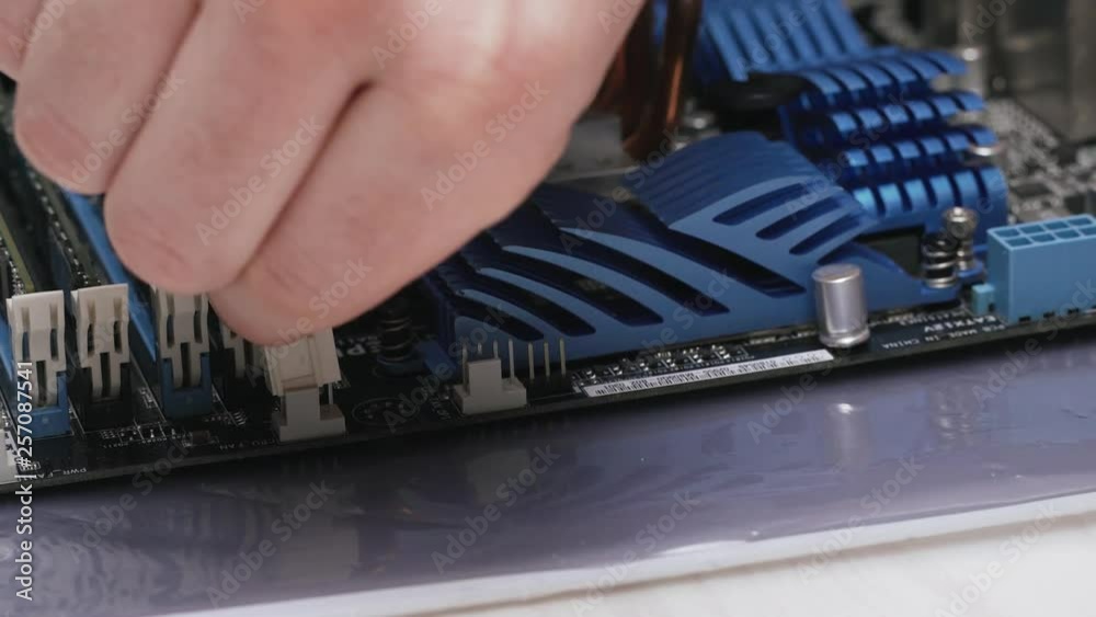 Build a computer, close-up view, 4K. A male service worker connects a ...