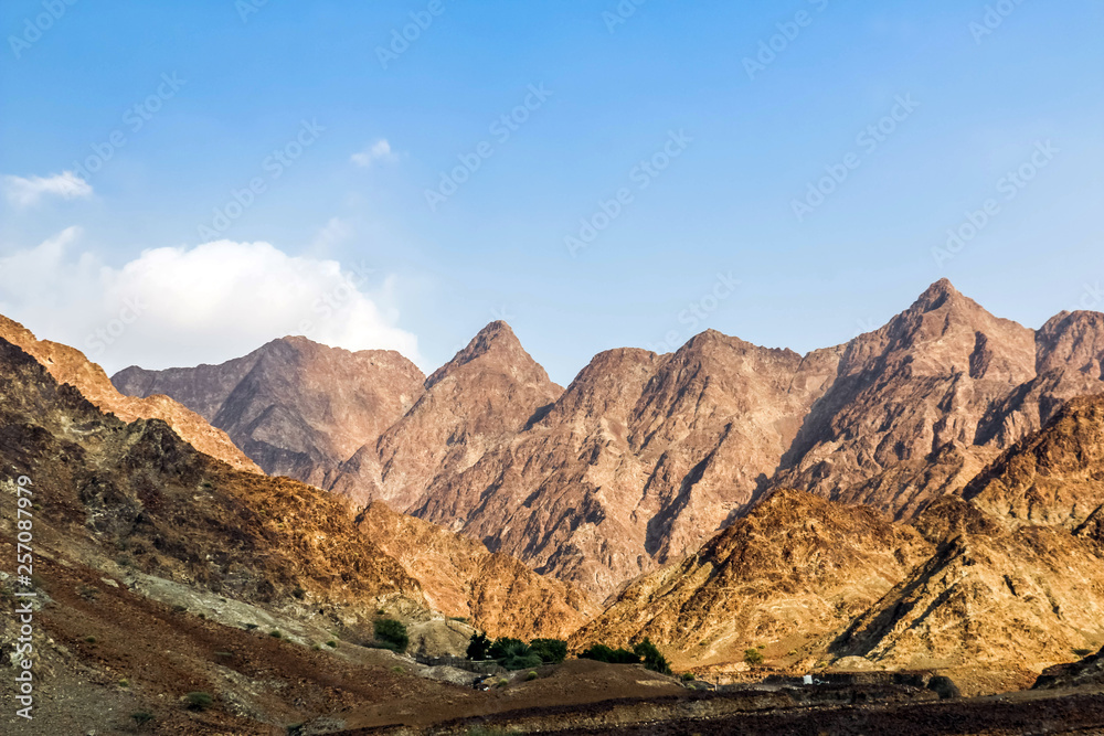 Geological landscape of Jabal Jais characterised by dry and rocky mountains, Road between mud mountains in Ras Al Khaimah, United Arab Emirates