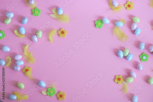 Kolorowe jajka, kwiatki i piórka na różowym tle, motyw wielkanocny
