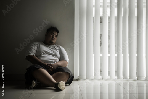 фотографія Lonely fat man looks daydream near the window