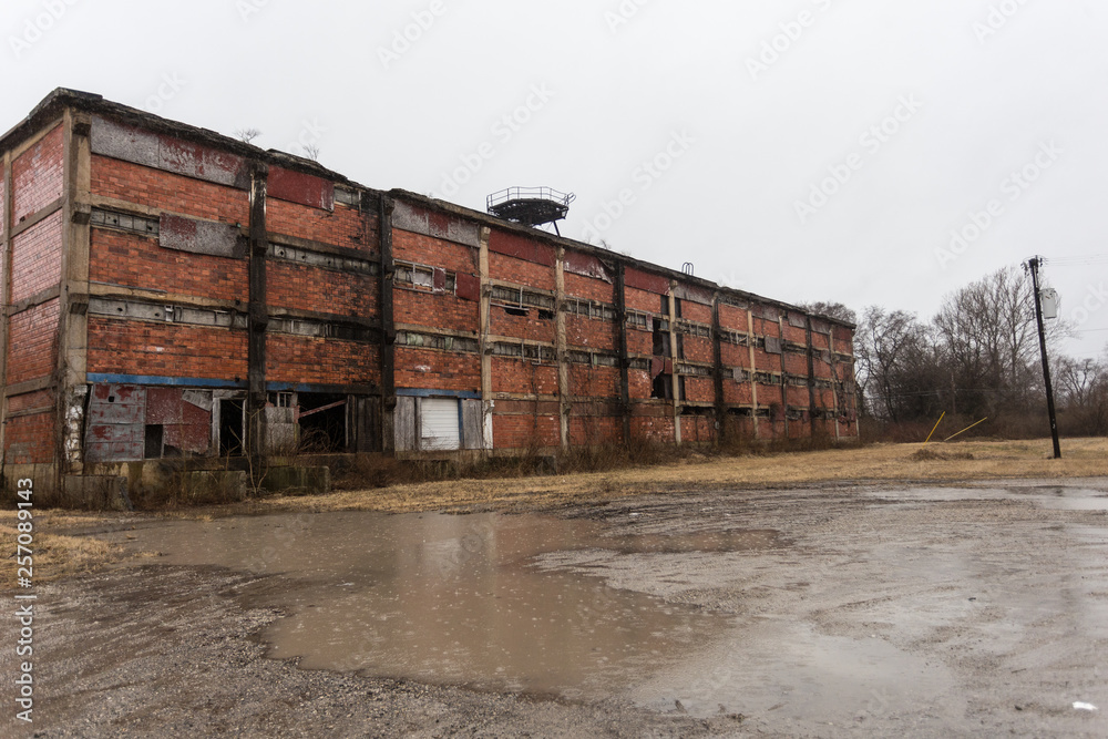 Large abandoned factory on edge of depressed urban area