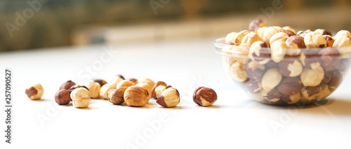 Healthy food for background image close up hazelnuts. Nuts texture on white grey table top view on the cup plate