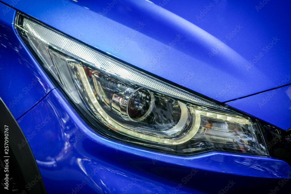 Close-up LED xenon headlight of blue modern car with halogen lamp technology for illuminate both day and night.