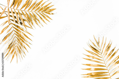 Gold tropical palm leaves on white background. Flat lay, top view minimal concept.